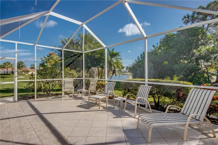 Screened-in patio featuring white aluminum framing, neutral ceramic tile flooring, and water frontage