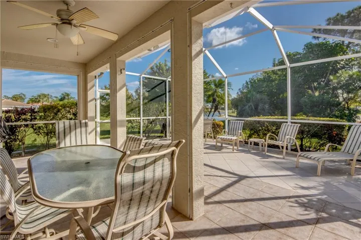 Covered lanai featuring tiled flooring, a ceiling fan, and a screened enclosure