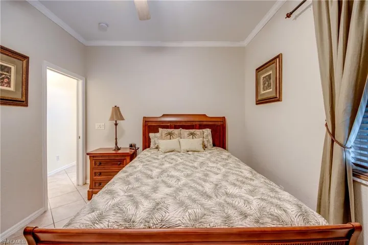 Neutral-toned interior walls, crown molding, and light-colored tile flooring