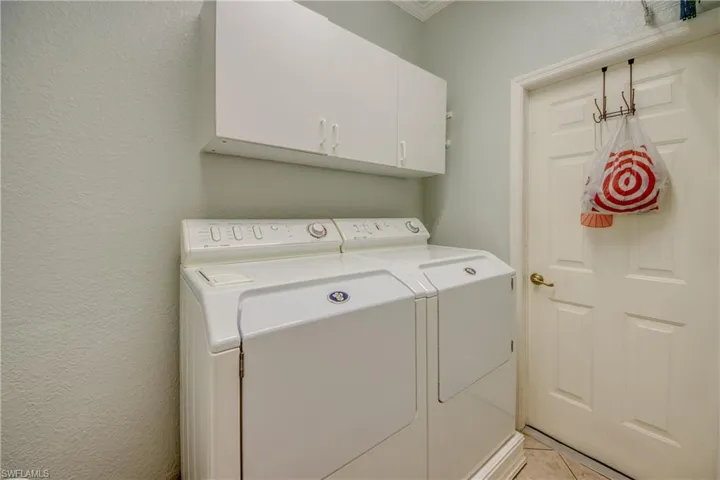 Laundry area featuring white wall-mounted cabinetry and a six-panel door