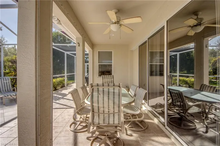 Covered patio featuring ceramic tile flooring, a ceiling fan, and a screened-in enclosure