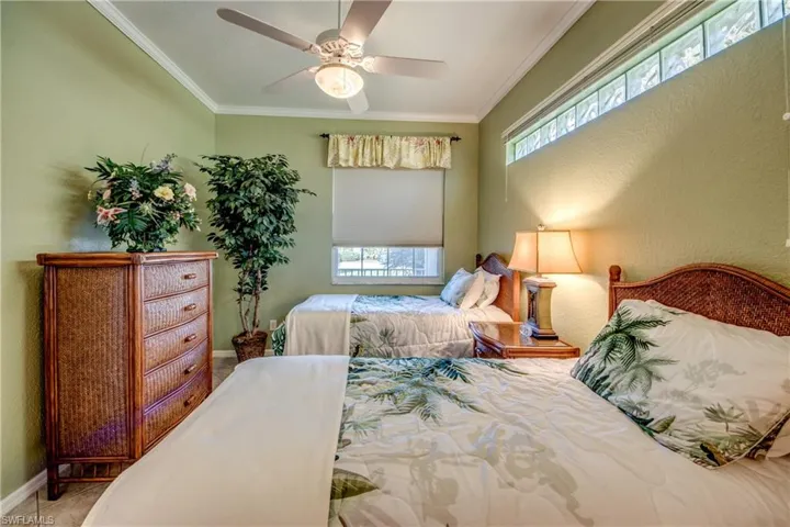 Room featuring a ceiling fan with integrated lighting, a clerestory window, and a standard rectangular window with a window treatment