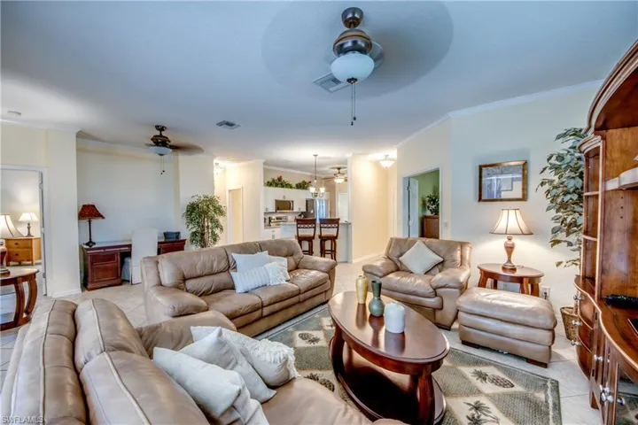Open-concept interior featuring light-toned tile flooring, recessed lighting, and multiple ceiling fans