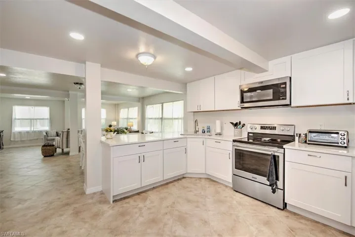 Kitchen featuring stainless steel appliances, a wealth of natural light, and white cabinets