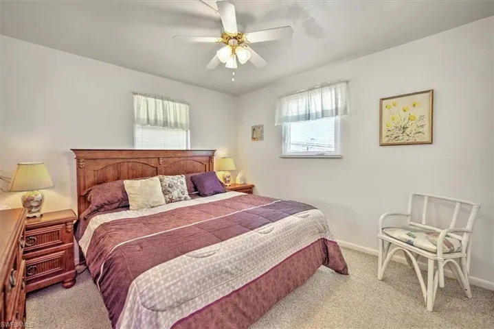 Carpeted bedroom featuring ceiling fan