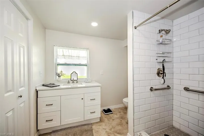 Bathroom with vanity, toilet, and a tile shower