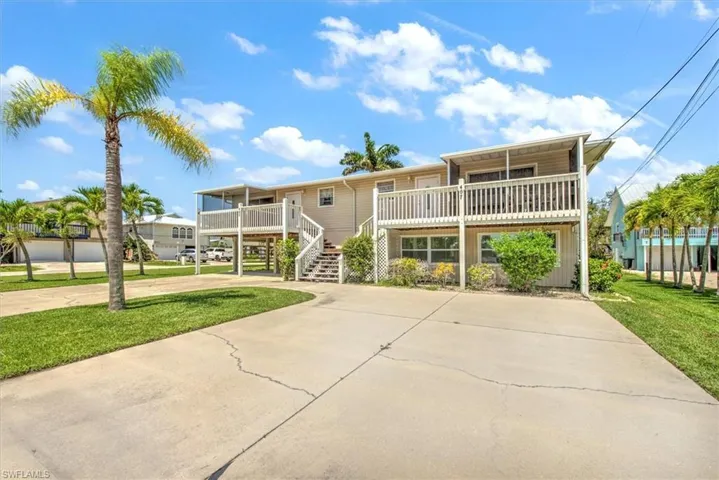 View of front of home featuring a balcony, covered porch, and a front yard