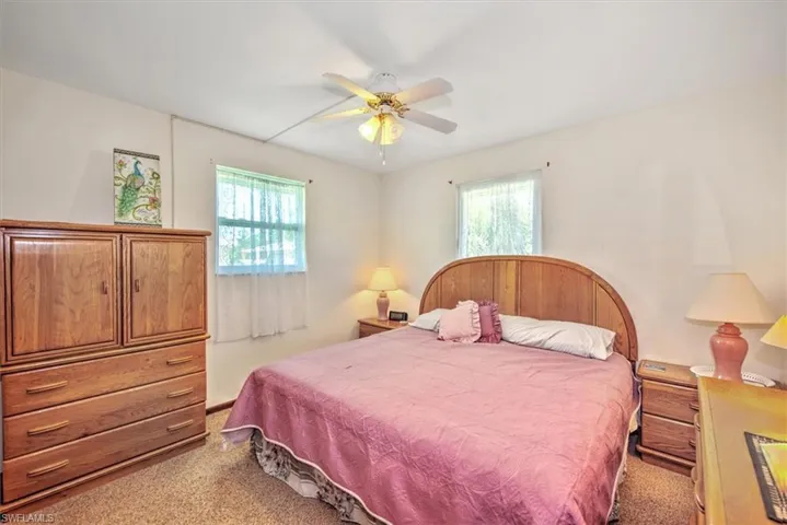 Carpeted bedroom featuring ceiling fan