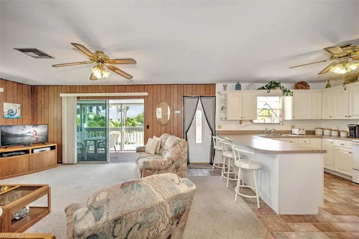 Kitchen featuring a center island, wooden walls, a breakfast bar, and light carpet
