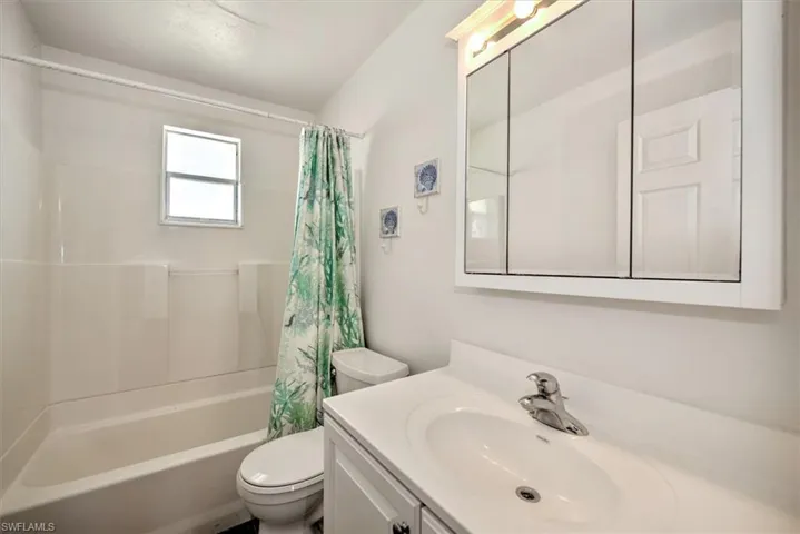 Full bathroom with shower / bath combo, vanity, and toilet