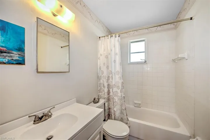 Full bathroom featuring vanity, toilet, and shower / bath combo with shower curtain