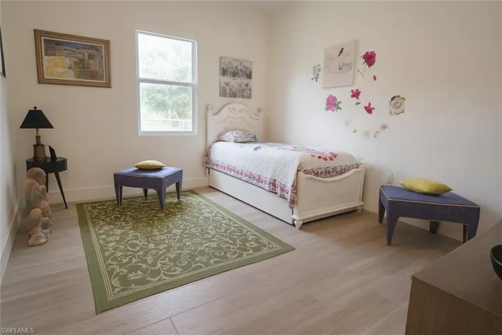 Bedroom with light wood finished floors and baseboards