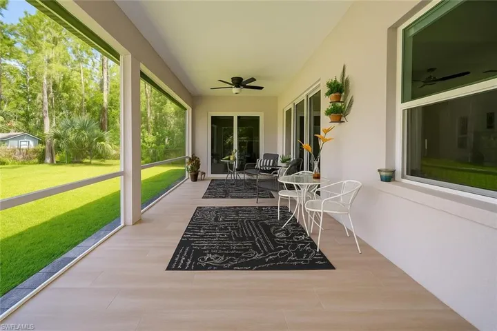 Sunroom with ceiling fan and a patio area