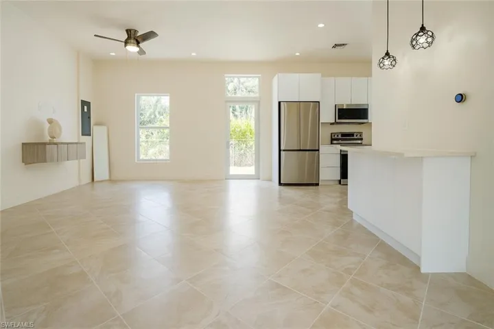 Unfurnished living room with a ceiling fan, light tile patterned flooring, recessed lighting, and electric panel