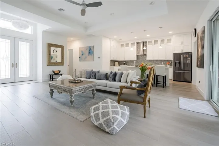 Living room with light wood finished floors, french doors, recessed lighting, and a ceiling fan
