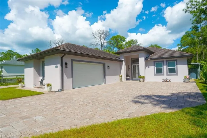 Prairie-style home with a garage, decorative driveway, stucco siding, and a tiled roof