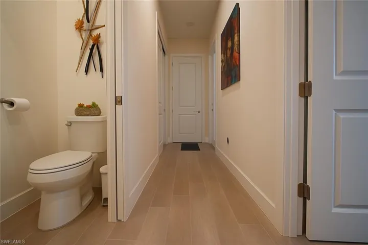 Hallway with baseboards and light wood-style floors