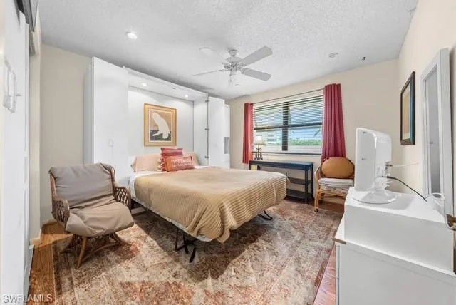 Bedroom featuring wood finished floors, a textured ceiling, a ceiling fan, and recessed lighting