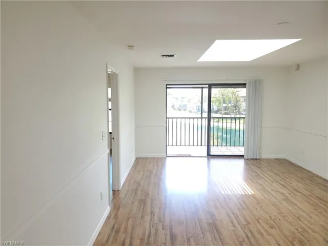 Empty room featuring light hardwood / wood-style floors and a skylight