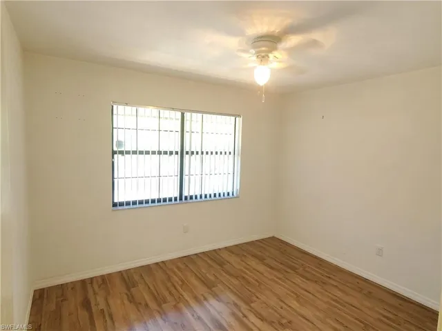 Spare room with wood-type flooring and ceiling fan