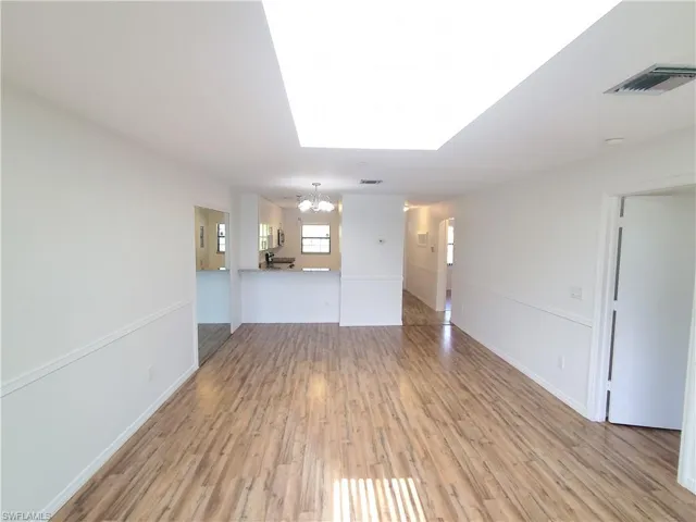 Unfurnished room with light hardwood / wood-style floors and a chandelier
