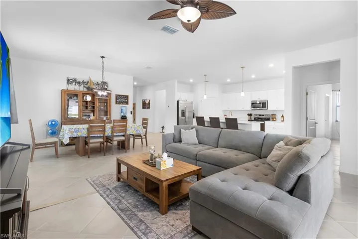 Living room featuring ceiling fan, recessed lighting, and light tile patterned flooring