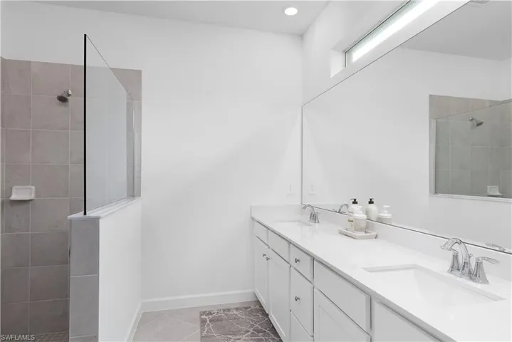 Bathroom with walk in shower and light tile patterned floors