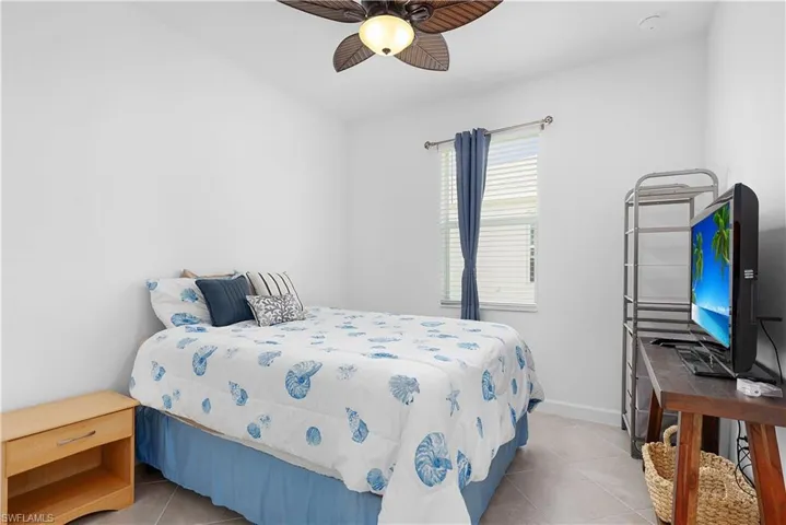Bedroom with light tile patterned flooring and ceiling fan