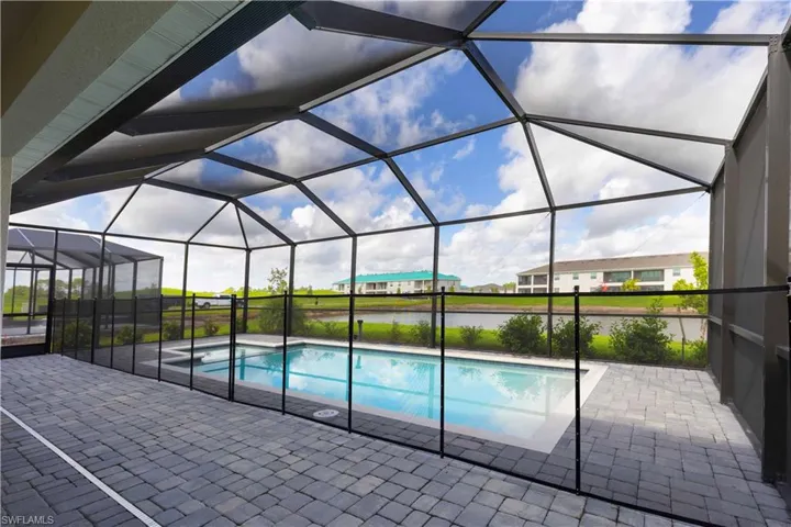 Outdoor pool featuring a sunroom, a patio, a lanai, a water view, and a residential view