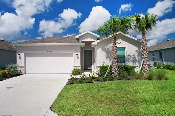 Ranch-style home with driveway, an attached garage, stucco siding, a front lawn, and stone siding