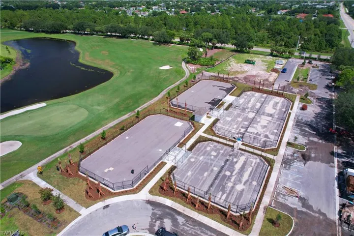 Aerial view of property and surrounding area with a golf course and a large body of water