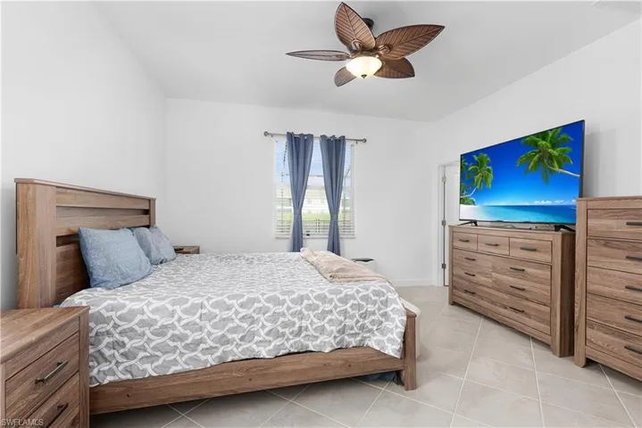 Bedroom featuring light tile patterned floors and ceiling fan