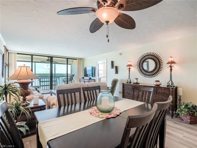Dining room with ceiling fan, porcelain tile flooring, crown molding, and a wealth of natural light