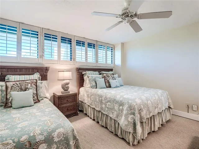 Carpeted guest bedroom with ceiling fan