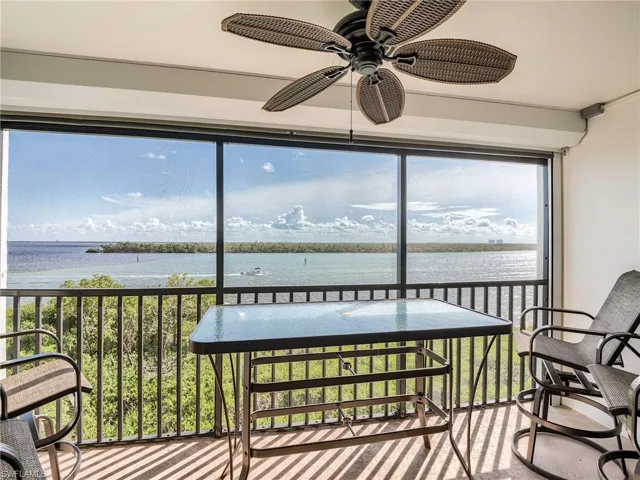 screened in balcony with a water view and ceiling fan