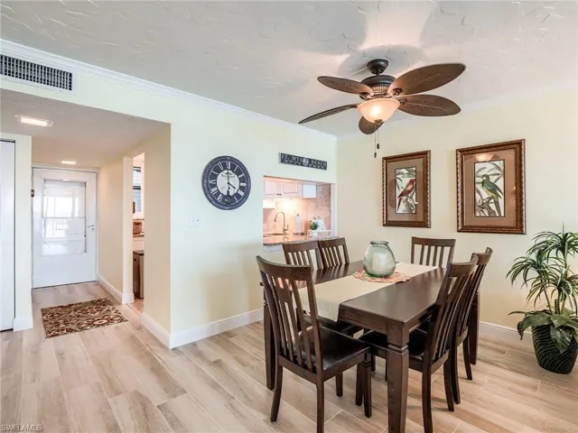 Dining area with new furniture in 2023, ornamental molding, ceiling fan, and porcelain tile floors  installed in 2022