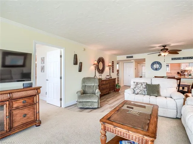 Carpeted living room with comfortable furniture with TV and Bose sound system