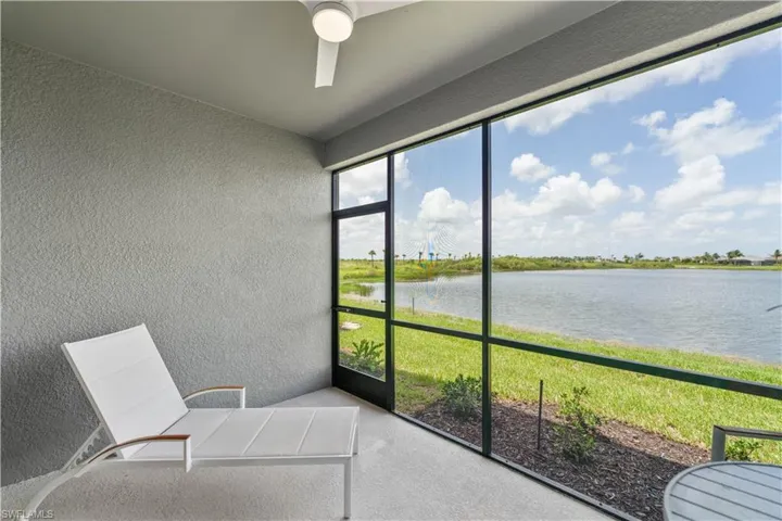 Unfurnished sunroom featuring a water view and ceiling fan