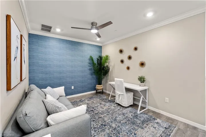 Office space featuring ceiling fan, hardwood / wood-style flooring, and ornamental molding
