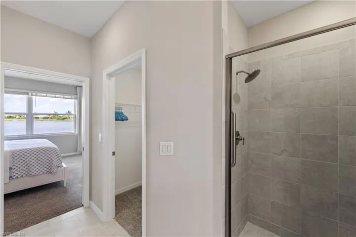 Bathroom featuring walk in shower and tile patterned flooring