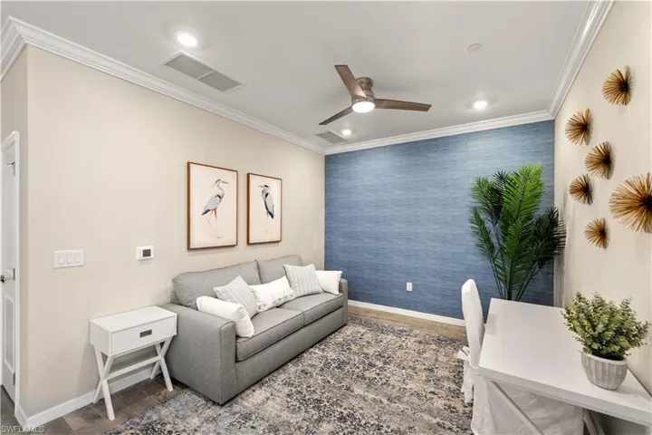 Living room featuring crown molding and ceiling fan