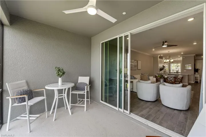 Sunroom featuring ceiling fan with notable chandelier