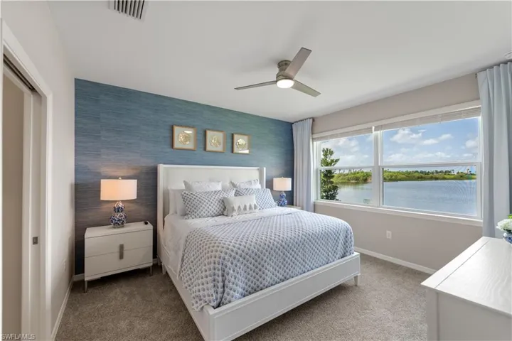Bedroom with a closet, a water view, carpet, and ceiling fan