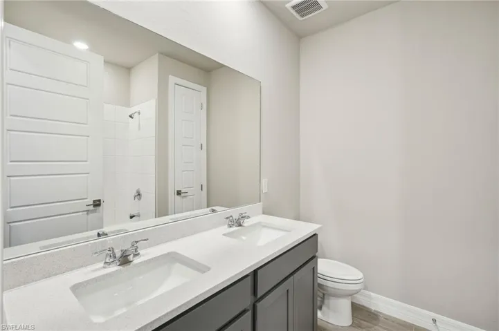 Full bathroom with shower / tub combination, vanity, toilet, and hardwood / wood-style floors