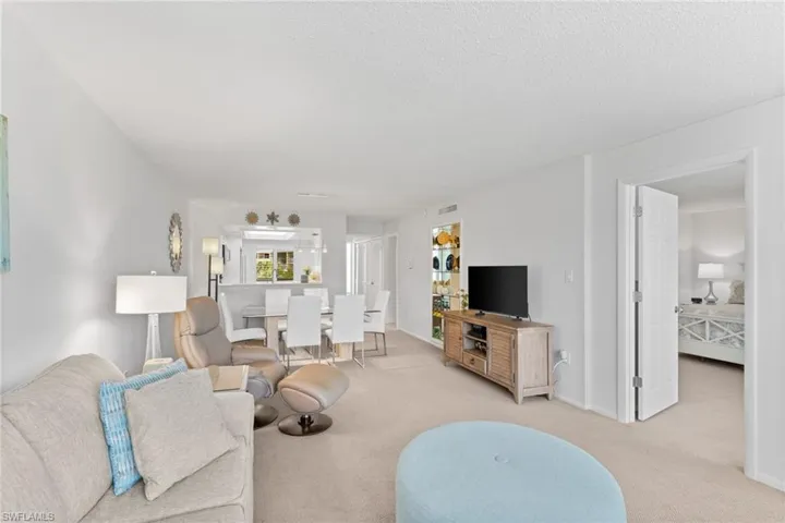 Living area featuring light colored carpet and a textured ceiling