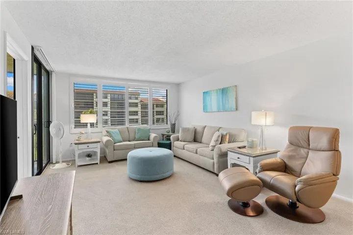 Living room featuring carpet and a textured ceiling