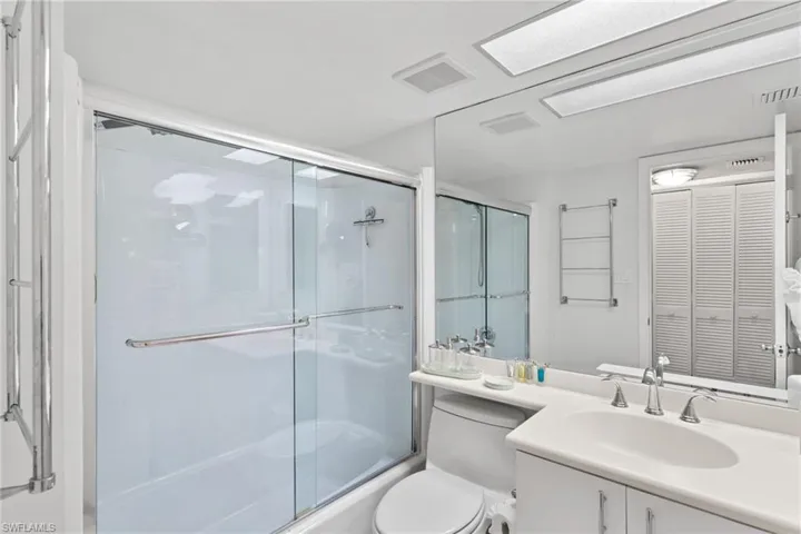 Primary Bathroom with vanity, enclosed tub / shower combo, and a closet