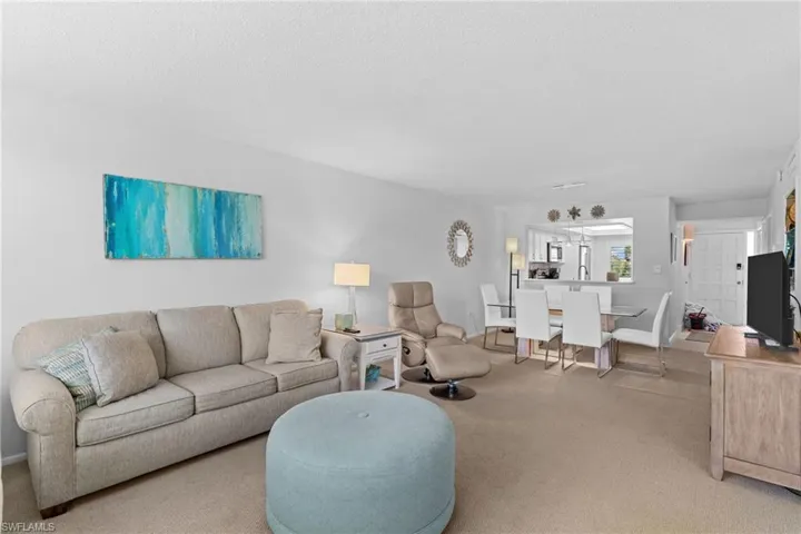 Living room featuring light carpet and a textured ceiling