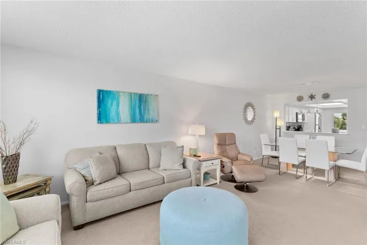 Living room featuring light carpet and a textured ceiling