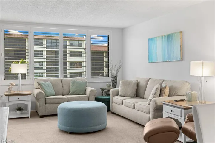 Carpeted living room featuring a textured ceiling